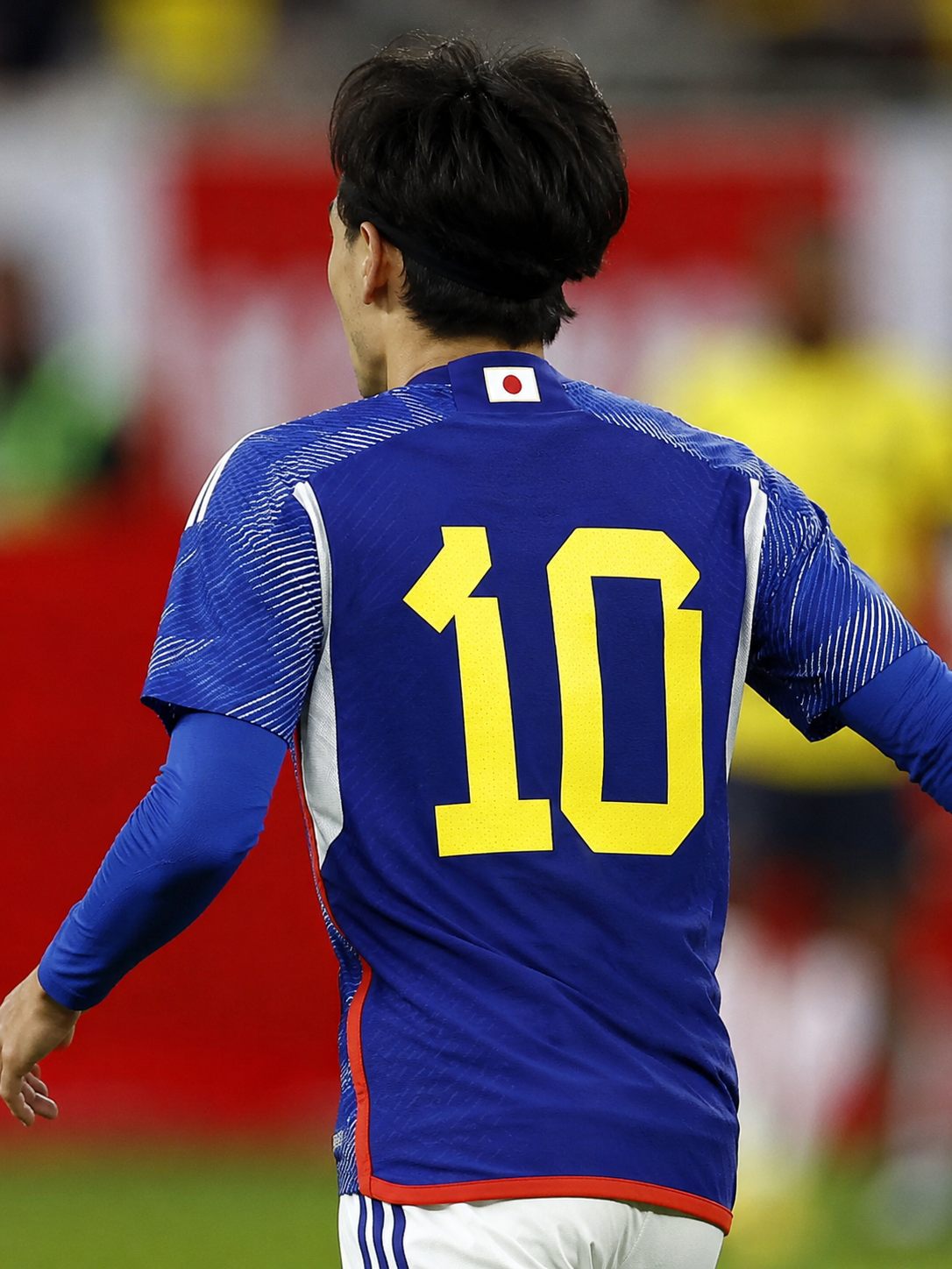 Jogador da seleção japonesa de costas usando a camisa azul número 10 do Japão