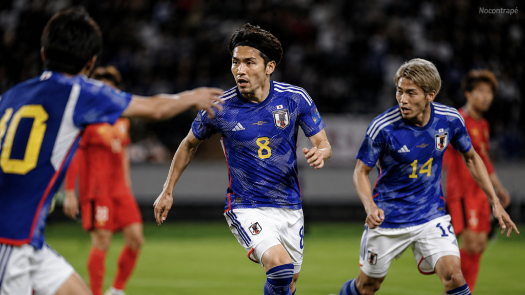 Jogadores da seleção japonesa usando camisa azul em partida de futebol