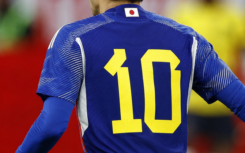 Jogador da seleção japonesa de costas usando a camisa azul número 10 do Japão